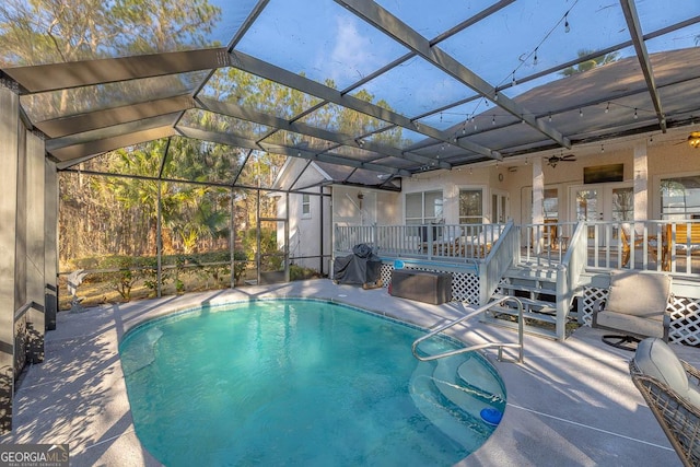 pool featuring glass enclosure and a patio