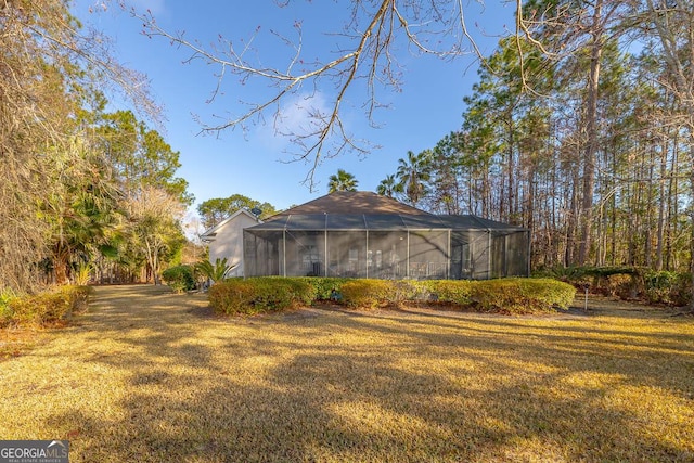 view of home's exterior featuring a lanai and a yard