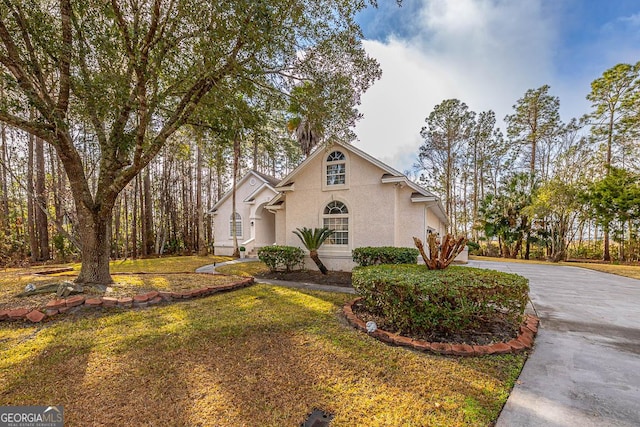 view of property exterior with a yard, driveway, and stucco siding