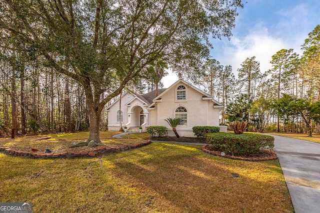 view of front of home featuring a front yard and stucco siding