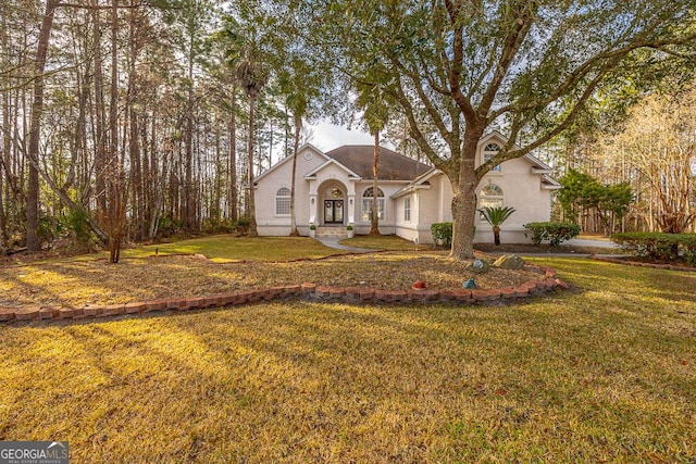 view of front of home with stucco siding and a front yard