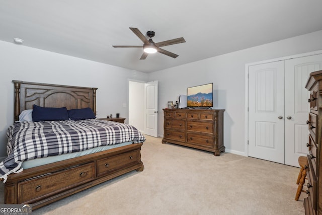 bedroom featuring light carpet, ceiling fan, and a closet