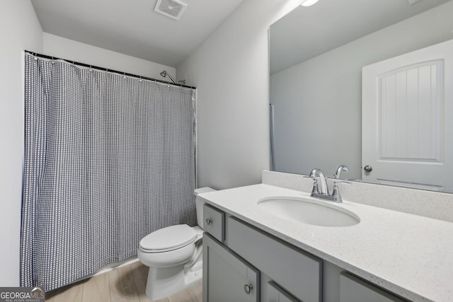 bathroom featuring wood-type flooring, vanity, and toilet