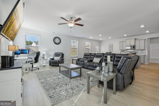 living room with light hardwood / wood-style floors and ceiling fan