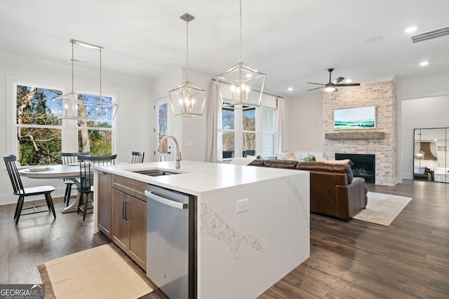 kitchen featuring plenty of natural light, a fireplace, a sink, dark wood-type flooring, and stainless steel dishwasher