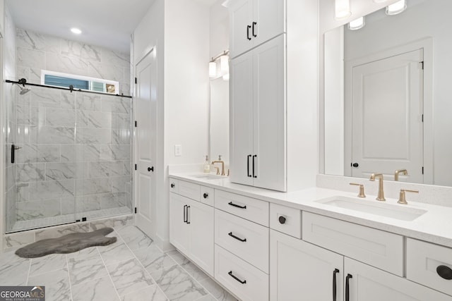 bathroom with a sink, marble finish floor, a stall shower, and double vanity