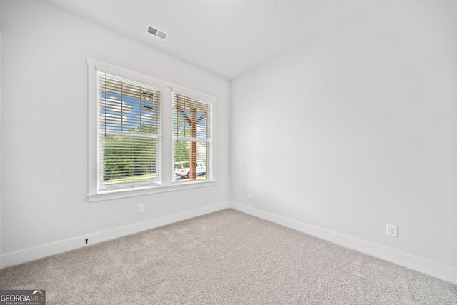 spare room featuring baseboards, carpet, and visible vents