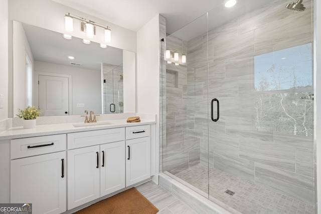 bathroom with a shower stall and vanity