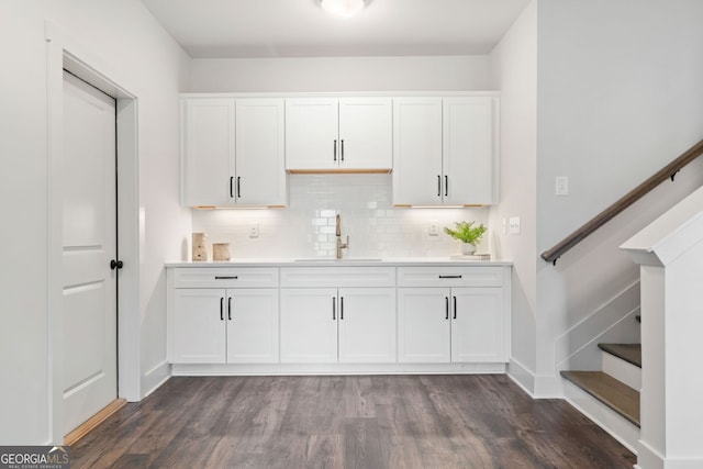 kitchen featuring white cabinetry, light countertops, decorative backsplash, and a sink