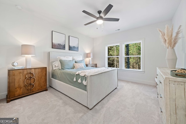 bedroom with visible vents, light colored carpet, a ceiling fan, and baseboards