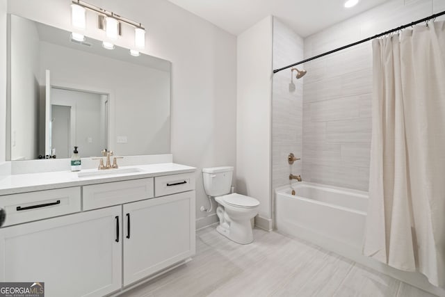 bathroom with vanity, toilet, shower / bath combo with shower curtain, and baseboards