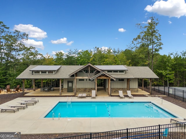 pool with a patio and fence