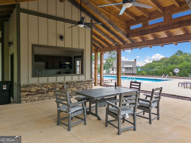 view of patio featuring a community pool, ceiling fan, outdoor dining space, and fence