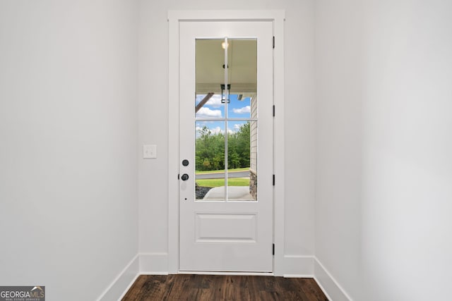 doorway to outside with baseboards and dark wood-type flooring