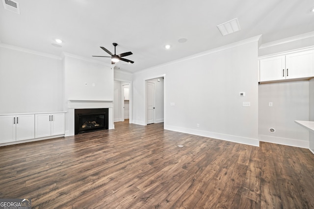 unfurnished living room featuring a ceiling fan, visible vents, dark wood-style floors, a glass covered fireplace, and ornamental molding