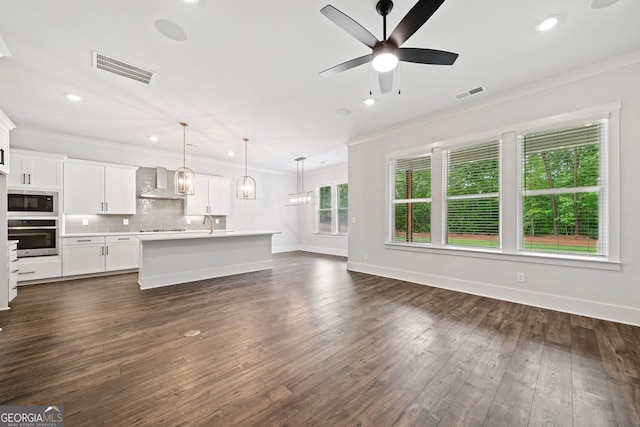 kitchen with backsplash, custom range hood, a sink, white cabinets, and stainless steel appliances