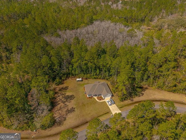 birds eye view of property featuring a forest view