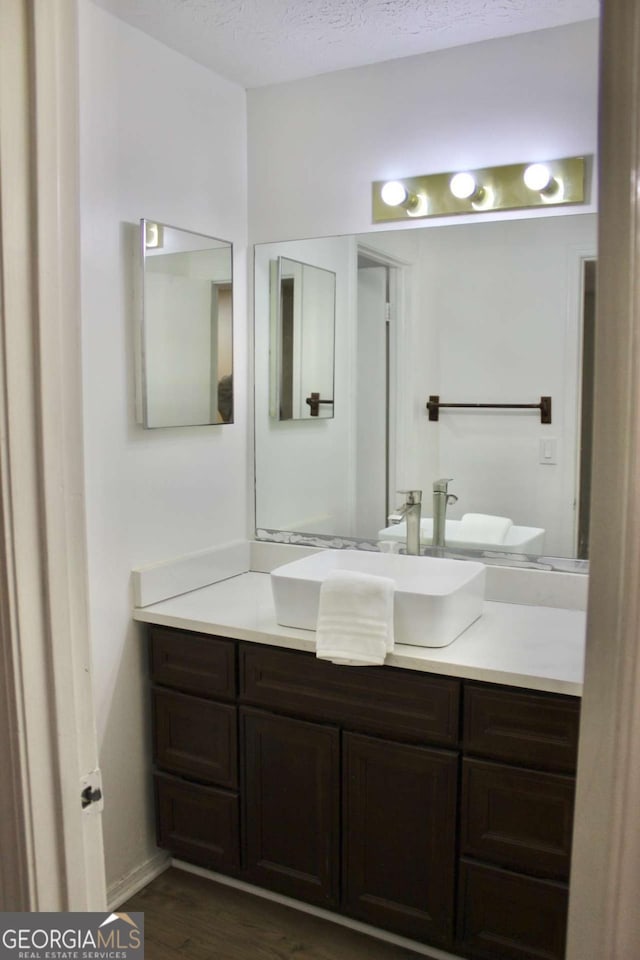 507 Augusta Dr SE, Marietta, GA 30067 - bathroom with vanity, wood-type flooring, and a textured ceiling