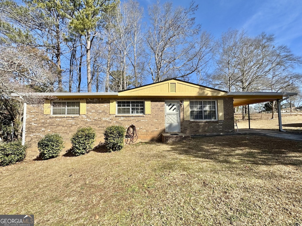 single story home featuring a carport and a front lawn