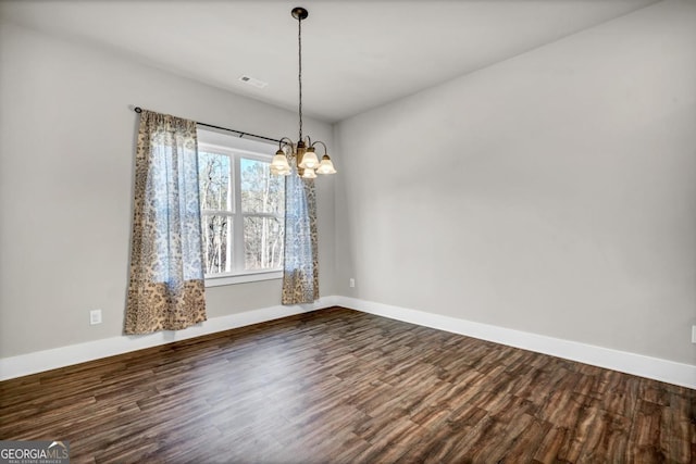 unfurnished room featuring an inviting chandelier and wood-type flooring