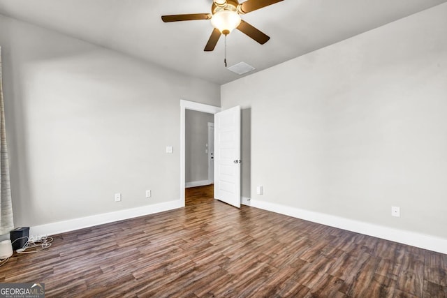 spare room with dark hardwood / wood-style flooring and ceiling fan