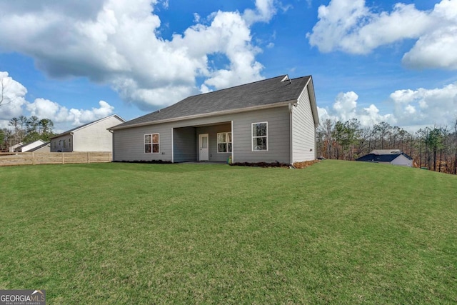 rear view of house featuring a yard