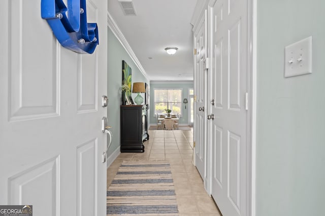 corridor featuring light tile patterned flooring and ornamental molding