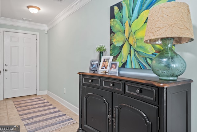 entryway with light tile patterned floors and crown molding