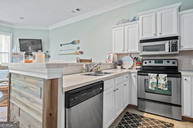 kitchen with sink, appliances with stainless steel finishes, white cabinetry, backsplash, and kitchen peninsula