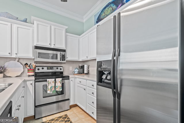 kitchen with light tile patterned floors, appliances with stainless steel finishes, white cabinetry, ornamental molding, and decorative backsplash