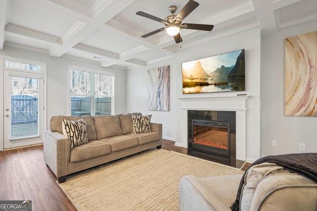 living area with a glass covered fireplace, wood finished floors, coffered ceiling, beamed ceiling, and baseboards