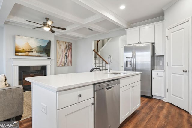 kitchen featuring white cabinetry, appliances with stainless steel finishes, sink, and a kitchen island with sink