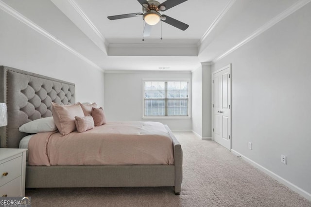 bedroom with crown molding, light colored carpet, a tray ceiling, and ceiling fan