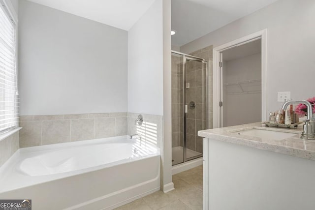 bathroom with vanity, shower with separate bathtub, a wealth of natural light, and tile patterned floors