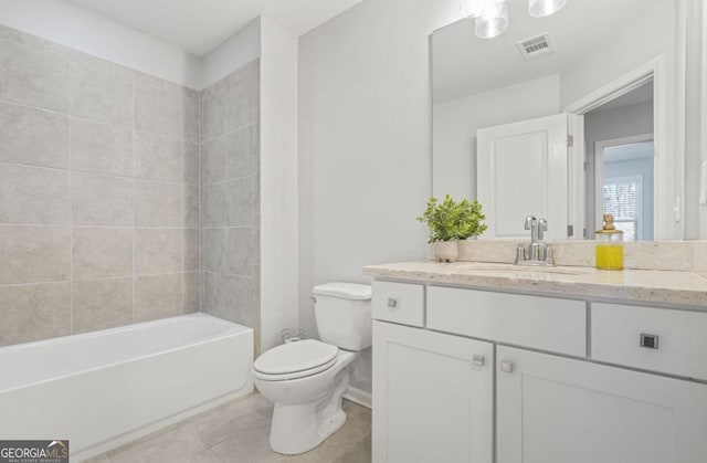 full bathroom featuring vanity, toilet, tiled shower / bath combo, and tile patterned flooring