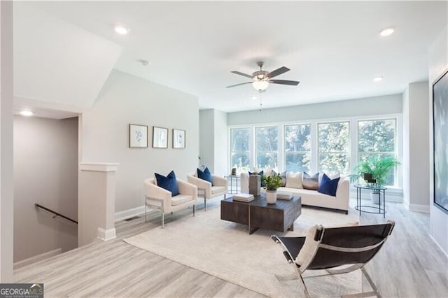 living room with ceiling fan and light hardwood / wood-style flooring