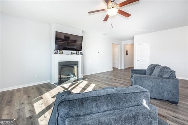 living room featuring ceiling fan and dark hardwood / wood-style floors