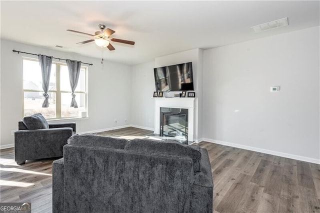 living room featuring ceiling fan and dark hardwood / wood-style flooring