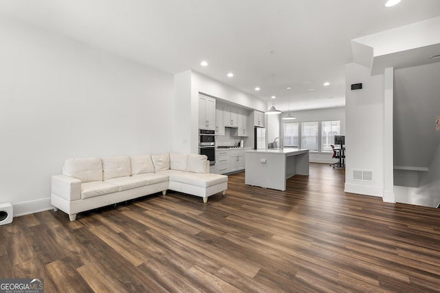 unfurnished living room featuring dark hardwood / wood-style flooring and sink