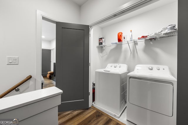 washroom with dark hardwood / wood-style flooring and washing machine and clothes dryer