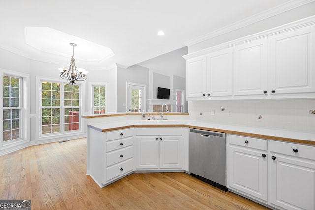 kitchen with sink, white cabinetry, hanging light fixtures, light wood-type flooring, and stainless steel dishwasher