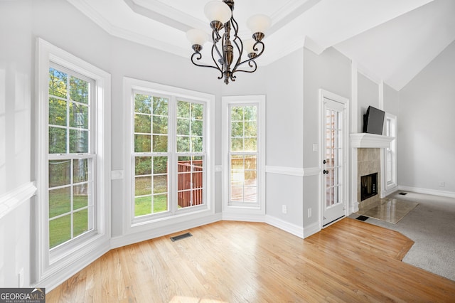 dining space with a wealth of natural light, a fireplace, a chandelier, and light wood-type flooring