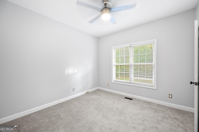 carpeted spare room with ceiling fan