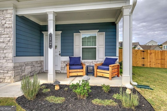 entrance to property with a yard and covered porch