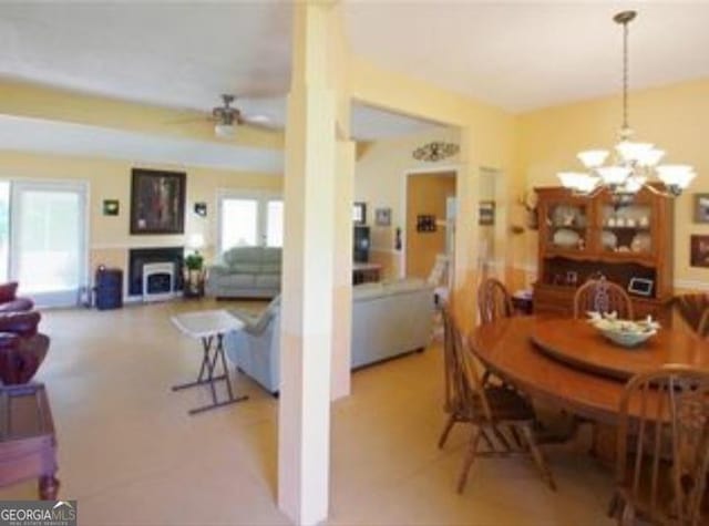 dining area with ceiling fan with notable chandelier