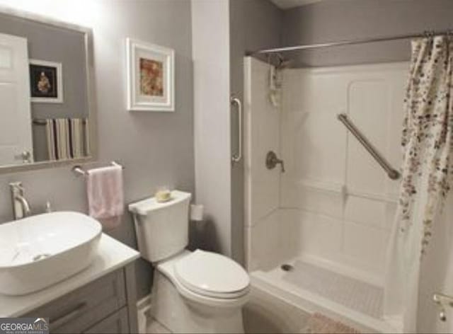 bathroom with vanity, toilet, and walk in shower