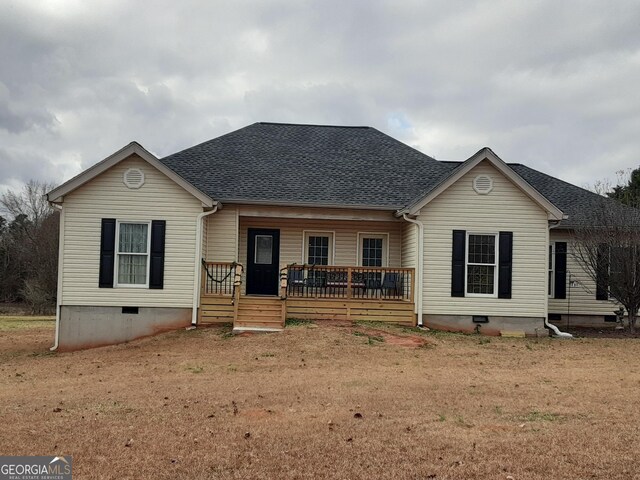 back of house with covered porch and a lawn