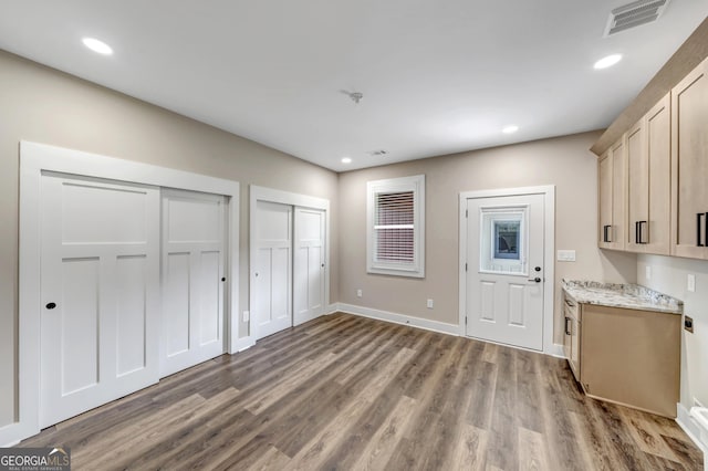 interior space with hardwood / wood-style flooring, light brown cabinetry, and light stone countertops