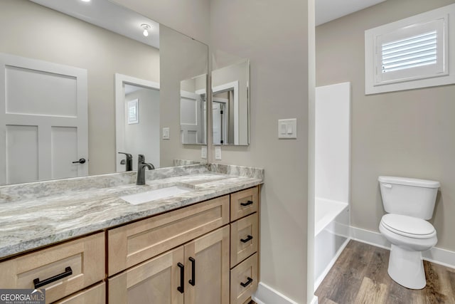 full bathroom featuring vanity, hardwood / wood-style flooring, shower / bathtub combination, and toilet