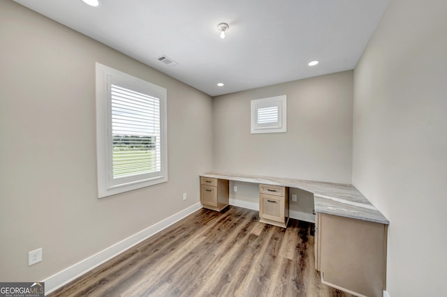 office space with built in desk and light wood-type flooring